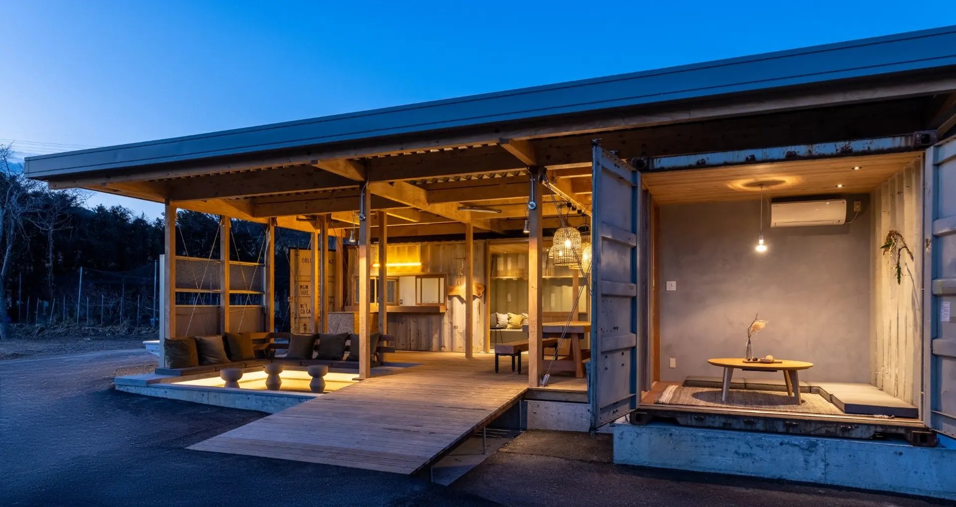 夕暮れに明かりがともる木の建物と、こたつの小部屋